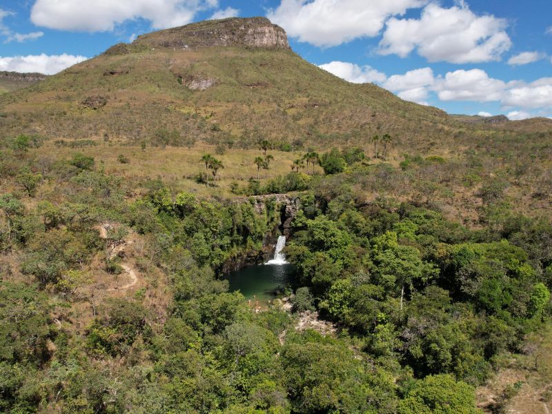Montanha e paisagem de cerrado em Cavalcante, com uma cachoeira ao fundo