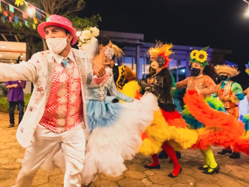 Imagem de um grupo de pessoas vestidos com roupas típicas de Festa Junina para dançar quadrilha.
