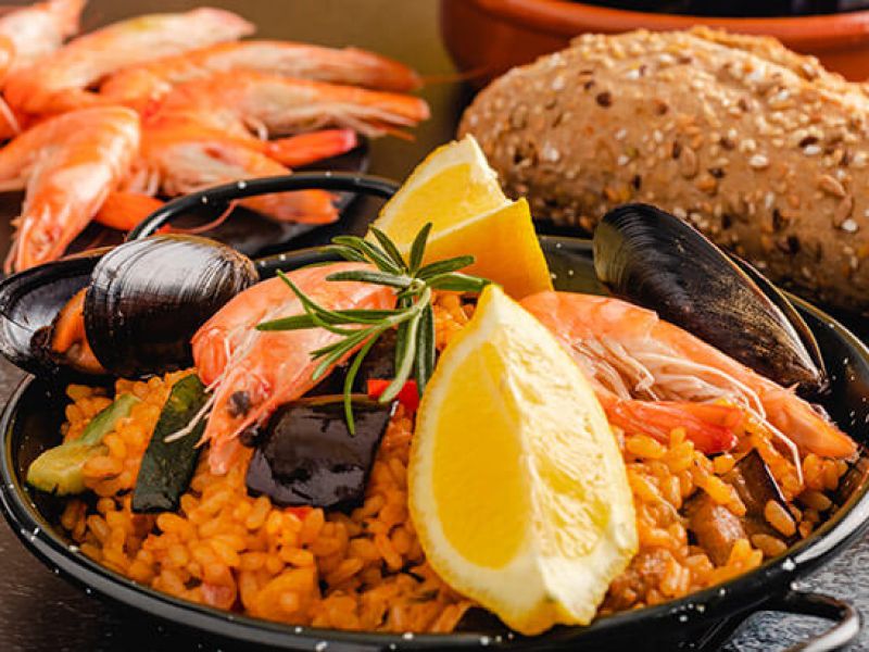 porção de paella, prato típico da culinária mediterranea, servido em mesa