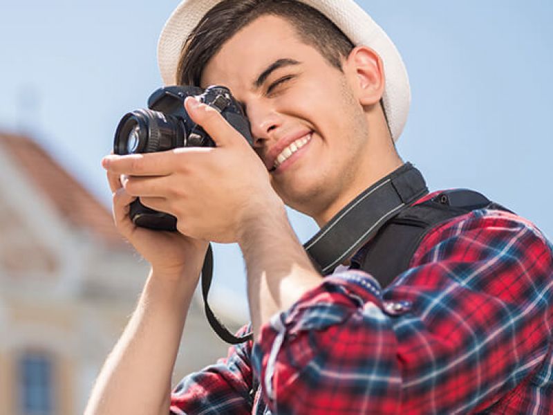 homem sorridente tirando foto durante seu turismo cultural