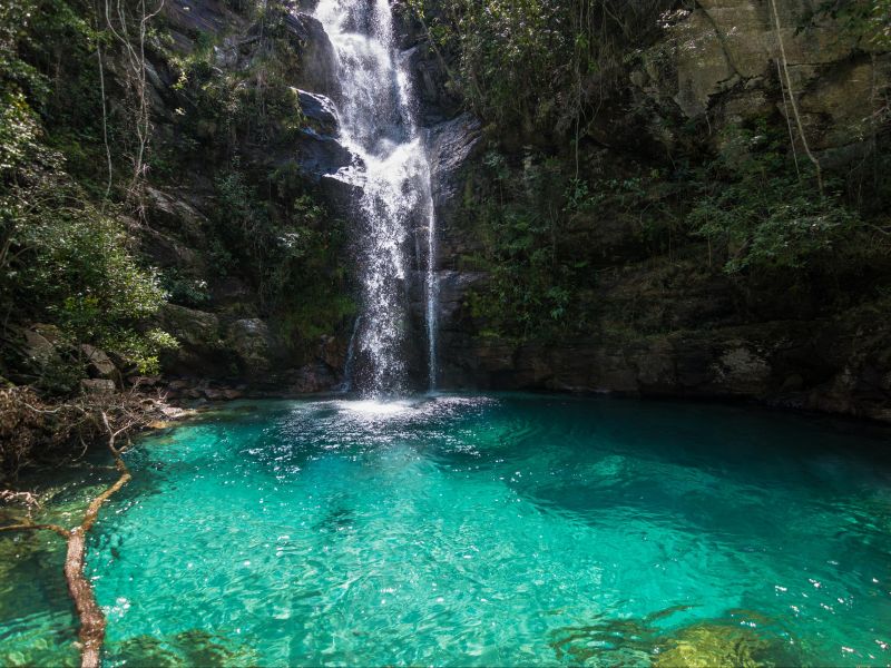 cachoeira na chapada dos veadeiros. Poço de água esverdeada e cristalina no fundo de um paredão de pedra que cerca a queda d'água