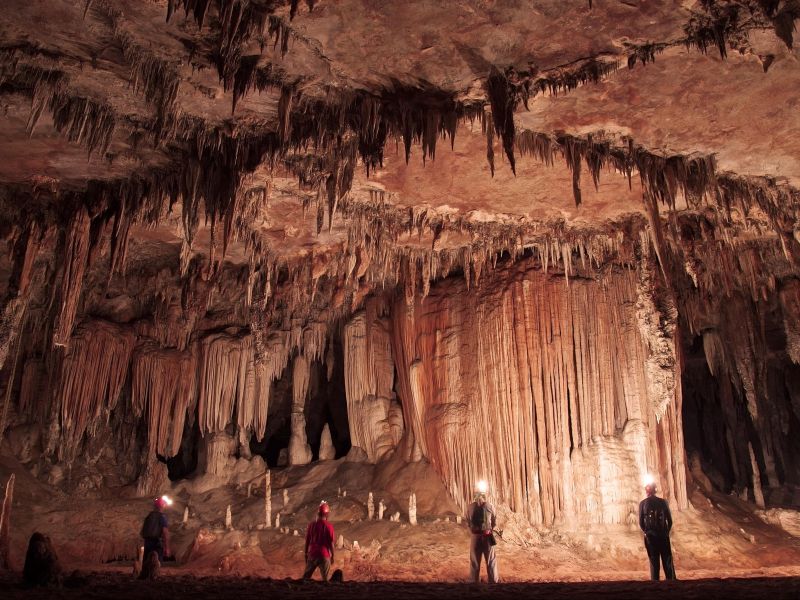 Pessoas paradas de costas observando o completo de Cavernas de Terra Ronca