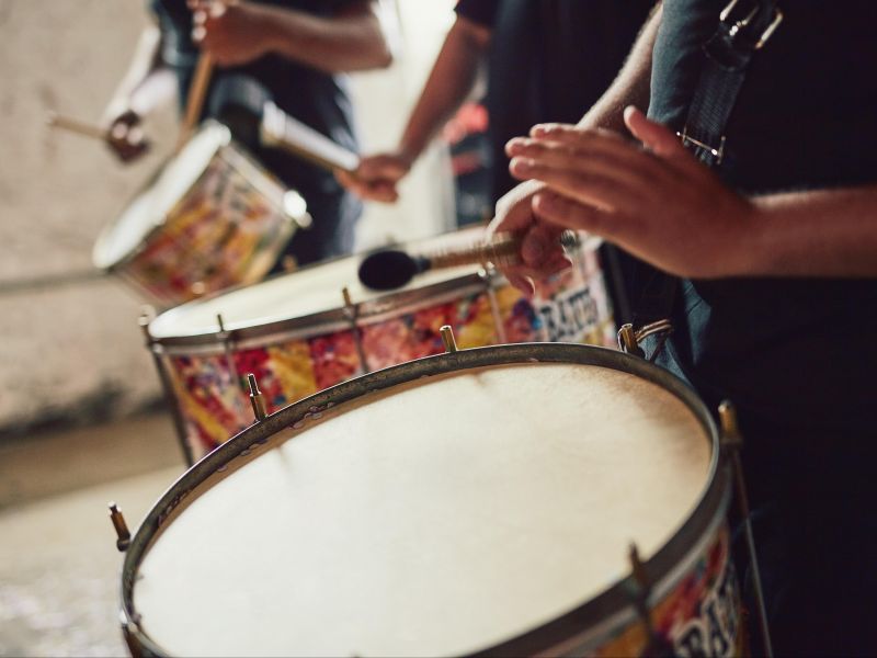 Parte de mãos e braços de pessoas tocando tambores