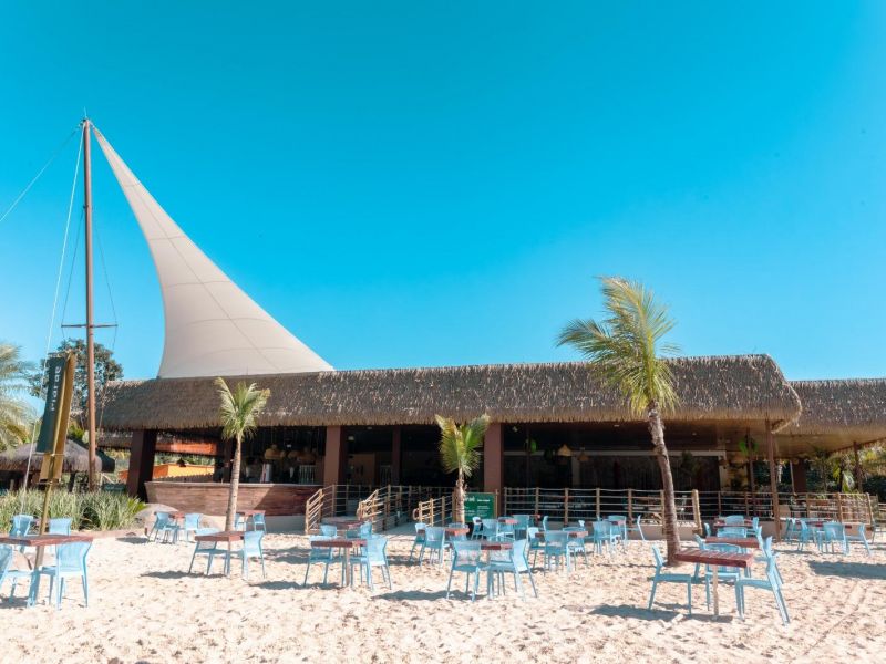 Um dos restaurantes do Hot Park, com cadeiras e mesas espalhadas pela areia da praia artificial