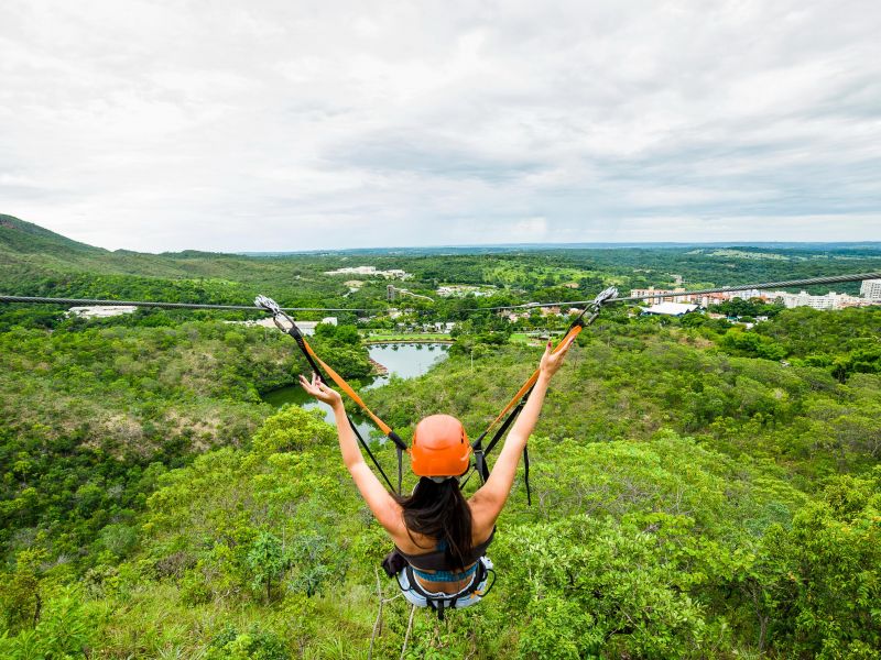 Mulher fazendo tirolesa por cima do complexo do Rio Quente